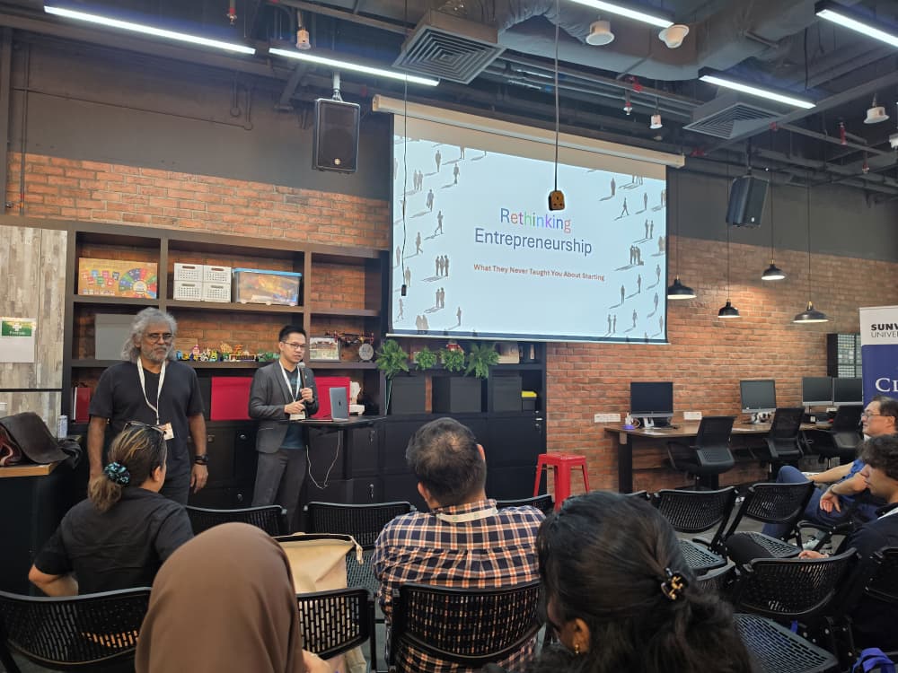 Speaker presenting "Rethinking Entrepreneurship: What They Never Taught You About Starting" slide presentation during a breakout session at the Internet Alliance Business Summit 2026 at Sunway University.